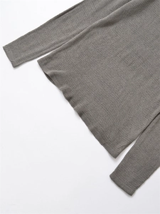 Dettaglio della maglia fine e dell'orlo a coste di un maglione invernale grigio