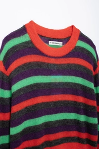 Detail of colorful striped knit sweater with vibrant orange and purple fuzzy texture
