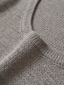 Dettaglio dello scollo in maglia a coste su un maglione a maniche lunghe girocollo