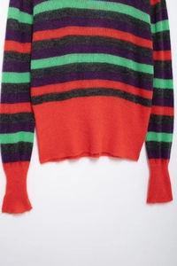 Detail of striped knit sweater showing colorful red, green, purple and grey textured wool fabric