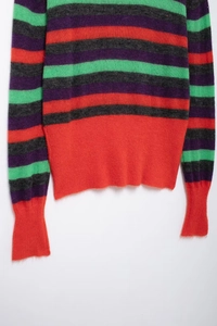 Detail of multi-color striped knit sweater showing fuzzy wool texture and red ribbed hem