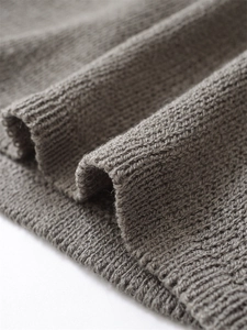 Dettaglio ravvicinato di maglia grigio talpa con texture a costine e bordo rifinito fine