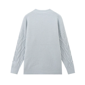 Detail eines hellblauen Strickpullovers mit Wabenstruktur und klassischen Zopfstrickärmeln