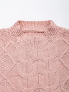 Nahaufnahme von rosa Strickpullover mit geripptem Rundhals und grobem Zopfmuster