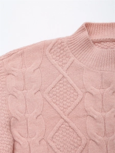 Detail eines rosa Zopfstrickpullovers mit aufwendigem Webmuster und geripptem Rundhals