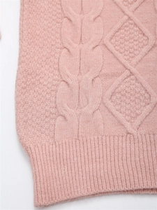 Detailaufnahme von pinkem Strickpullover mit aufwendigen Zopf- und Rautenmustern
