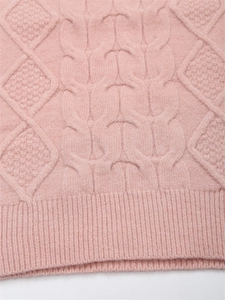 Detailansicht eines rosa Strickpullovers mit Zopfmustertextur und geripptem Saumabschluss