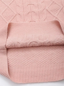 Detailaufnahme des rosa Strickpullovers mit Zopfmustern und geripptem Saum
