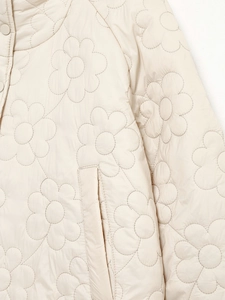Detail der weißen Steppjacke mit Blumenmuster-Steppung und elegantem Stehkragen-Design