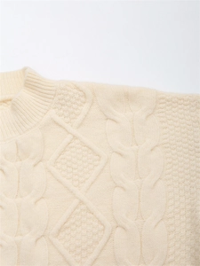 Detailaufnahme des cremeweißen Strickpullovers mit Zopfmuster und Wabenstruktur-Gewebe