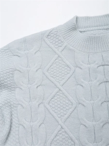Detaillierte Nahaufnahme von Zopf- und Rautenmustern auf weichem blauem Mohair-Strickpullover
