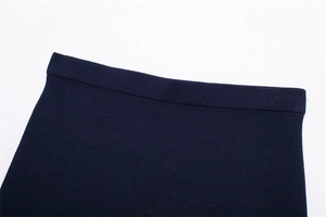 Detailed close-up of dark blue knit skirt waistline showing premium fabric texture