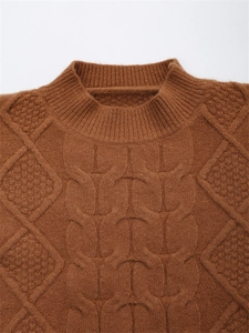 Detail der karamellfarbenen Zopfmuster-Textur und des Rundhalsausschnitts am Strickpullover