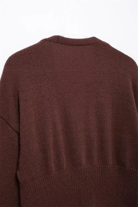Dettaglio del retro del cardigan in maglia marrone scuro con trama a nido d'ape