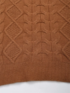 Nahaufnahme des braunen Strickpullovers mit Zopfmuster und Rautenstrickdetails