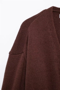 Dettaglio dello scollo a V e della spalla del cardigan in maglia marrone scuro