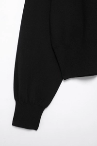 Macro detail of high-quality black knit texture and ribbed cuffs for women's outerwear