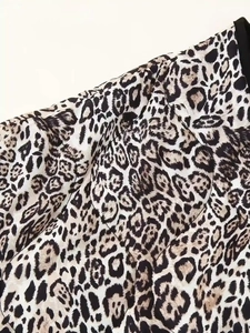 Detailed view of leopard print cotton jacket with black piping and textile texture