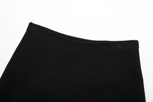 Detail of a minimalist black knitted skirt waistline with fine elastic texture
