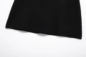 Detailed macro view of the finely ribbed hem and texture of a black knit garment