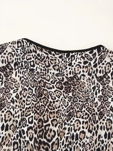 Detail of round neckline with black piping on leopard print lightweight cotton jacket