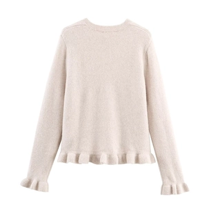 Dettaglio dei bordi a balze e della trama a maglia del maglione beige a girocollo