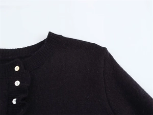 Dettaglio cardigan in maglia girocollo con bordi a costine e bottoni bianchi a contrasto