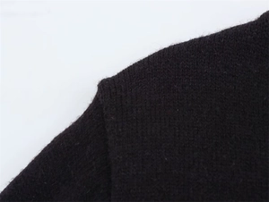 Dettaglio della cucitura della spalla e della morbida trama di questo maglione nero