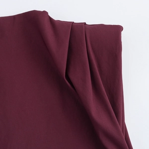 Dettaglio della trama del tessuto plissettato bordeaux sul top da donna moda