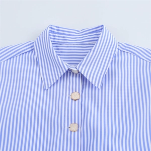 Détail du col d'une chemise en lin à rayures bleues et blanches avec boutons carrés