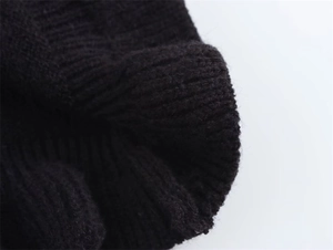 Dettaglio macro del tessuto a maglia a coste nere che mostra la trama densa e morbida