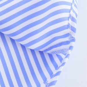 Vue macro détaillée du tissu à rayures bleues et blanches avec couture nette sur l'ourlet