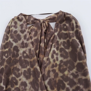 Detail shot of leopard print sheer mesh fabric with lace-up bow tie and elastic strap