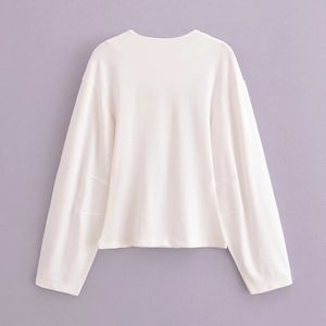 Gros plan détaillé d'un sweat-shirt blanc à manches longues avec plis latéraux uniques