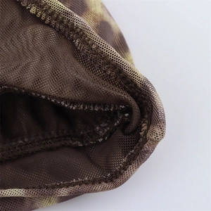 Macro detail of leopard print mesh fabric with high-quality reinforced stitching