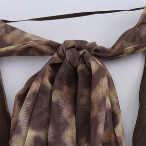 Detail of a mesh bodysuit featuring abstract tie-dye print and thin shoulder straps