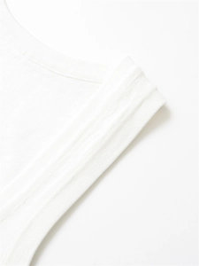Detailed close-up of white knit fabric texture and ribbed edge craftsmanship on the top