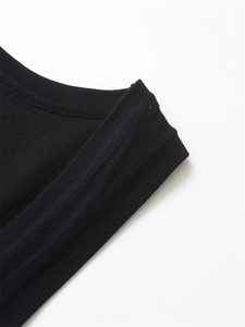 Detailed view of the fine ribbed texture and seamless stitching on this black knit top