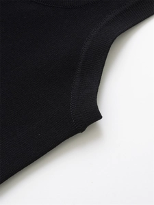 Detail shot of black knitted fabric with reinforced armhole stitching and fine texture