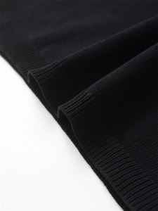 Detail of ribbed cuff on black knitted top showing premium fine weave texture