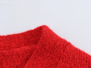 Detailaufnahme der roten Strickjacke mit weicher Mohair-Textur und feiner Strickkunst