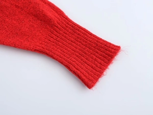 Makroaufnahme der gerippten Bündchen an roter Strickjacke mit feiner Textur