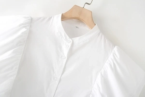 Dettaglio delle maniche a sbuffo e colletto alla coreana su camicia bianca donna