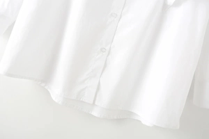 Dettagli dei bottoni trasparenti e cuciture fini su una camicia bianca di design