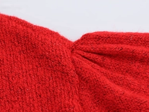Detailaufnahme der plissierten roten Strickware mit weicher Wollstruktur und Fasern