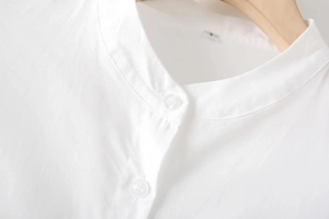 Dettaglio del colletto della camicia bianca in misto cotone con cuciture precise e bottoni