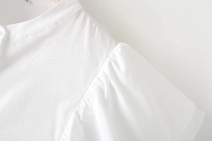 Dettaglio camicia bianca di design con maniche a sbuffo e cuciture arricciate spalla