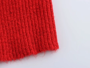 Detailaufnahme der roten Rippstrickstruktur mit dicken Wollfasern und weichem Finish