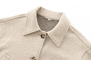 Close-up of oatmeal wool jacket lapel with premium brown buttons and size S neck label