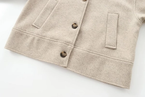Detail of oatmeal felt jacket showing wool blend texture and tortoiseshell buttons